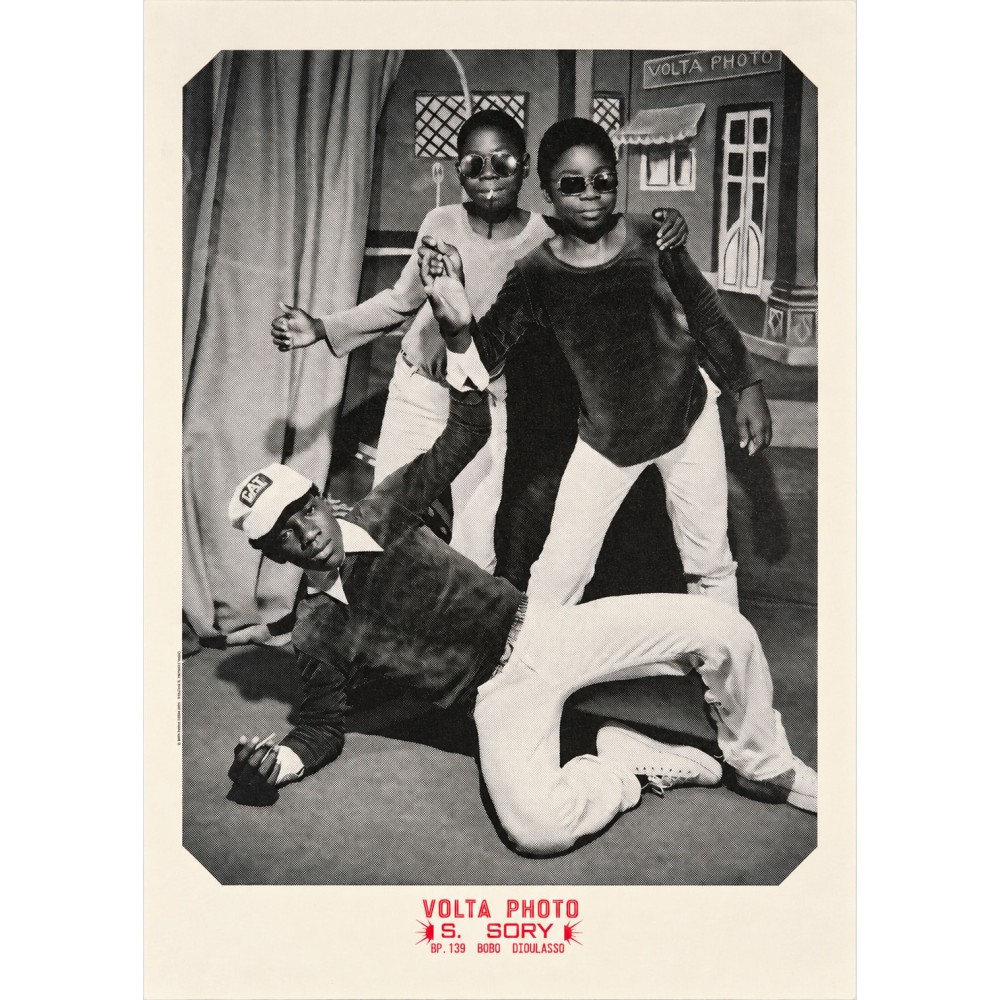Póster de Sanlé Sory, tres jóvenes ante la fachada pintada del estudio Volta Photo, en Bobo-Dioulasso